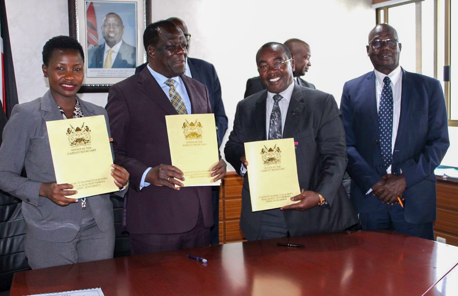 Various stakeholders pose for a photo after signing of the performance contract