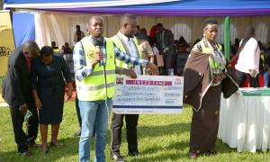 Member of Parliament Emgwen, Uwezo Fund CEO Mr. Lengapiani alongside Hon. Mang'eni as they are about to issue out Uwezo Fund cheque
